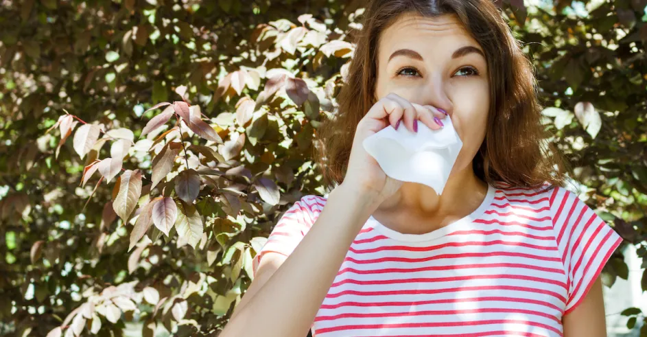 Woman With With Allergy Symptom Blowing Nose Park