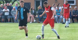 Zo zápasu Dubovce - Petrova Ves 0:1. V súboji o loptu Dávid Sloboda (s loptou) s hosťujúcim Michalom Balážom. zadu Frederik Vanek. Foto: Ivan Peťko